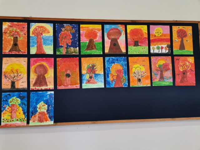 Prace plastyczne uczniów klasy 3a wykonane farbami plakatowymi „Jesienne drzewo o zachodzie słońca”.