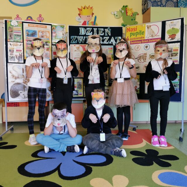 Obchody światowego Dnia Zwierząt w świetlicy szkolnej. Uczniowie prezentują się  w przygotowanych maskach zwierząt.