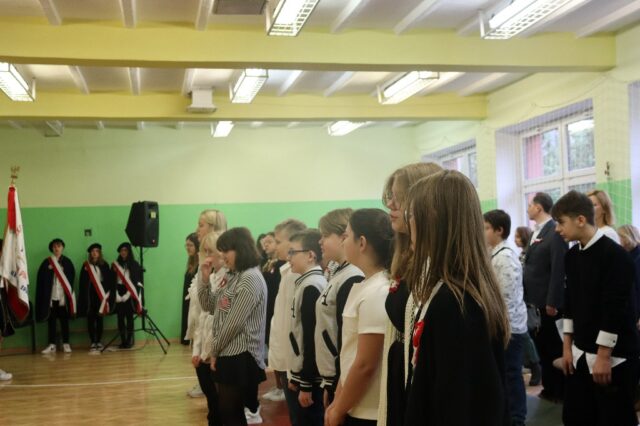 10 listopada odchodziliśmy w naszej szkole 104. rocznicę odzyskania przez Polskę niepodległości. Uczniowie klasy 6c i członkowie koła wokalnego przygotowali uroczystą akademię. Sala pełna uczniów. 