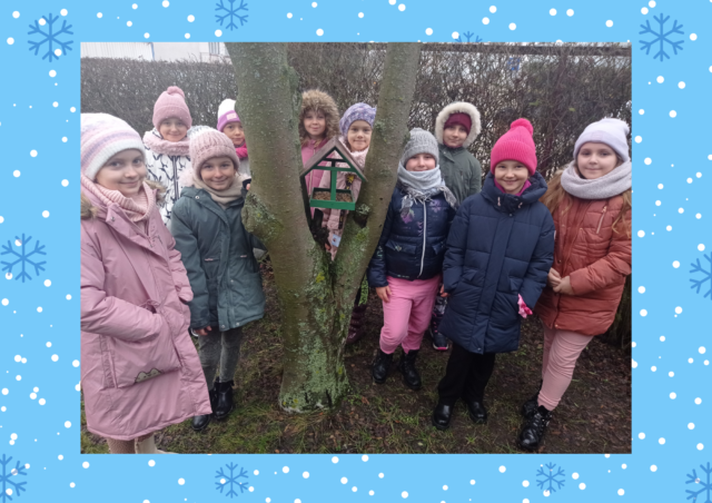 Ogólnopolski Projekt Edukacyjny „Eko Ludek”. Zdjęcie grupowe. Dziewczynki stoją przy drzewie, na którym zawieszony został karmnik.