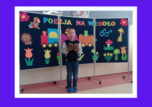 Konkurs recytatorski - Poezja na wesoło. Mikołaj stoi na tle dekoracji konkursowej i prezentuje wiersz pt. „Dwa jeże”.