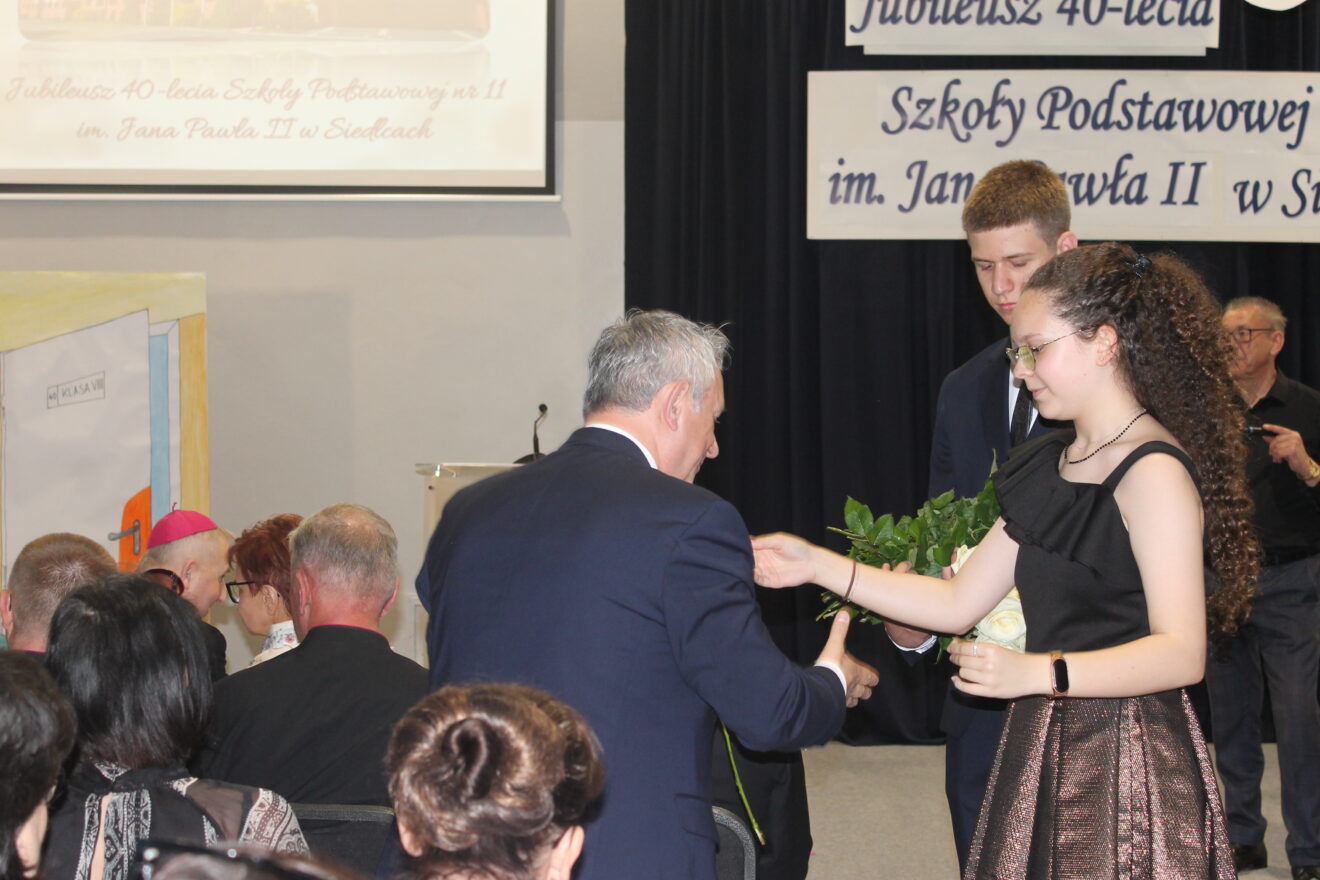 Jubileusz 40-lecia Szkoły Podstawowej nr 11 im. Jana Pawła II-uczniowie wręczają białe róże