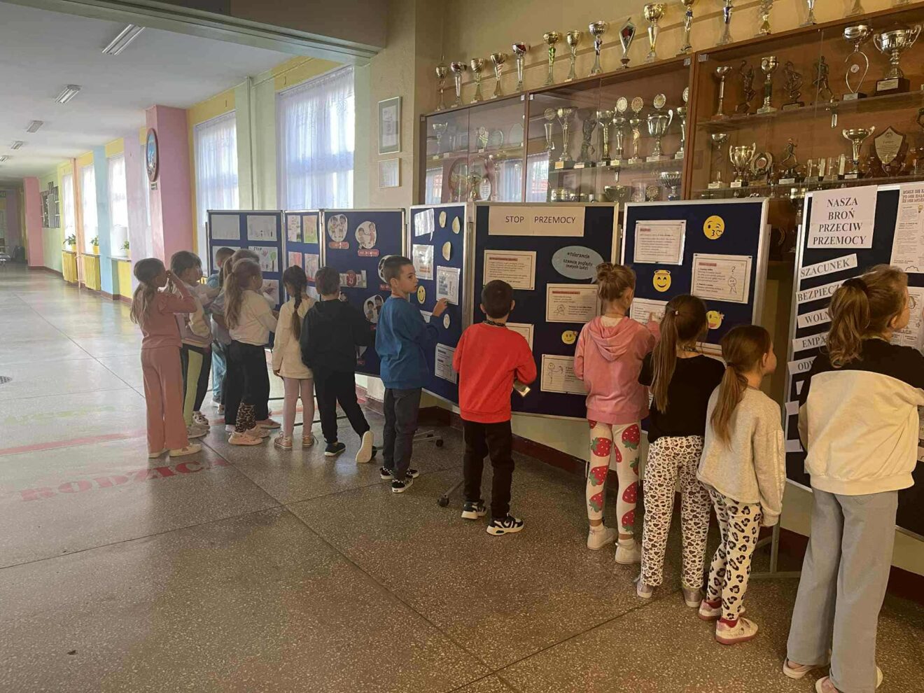 Zapoznawanie się z informacjami umieszczonymi na tablicach przez uczniów klasy 2c.