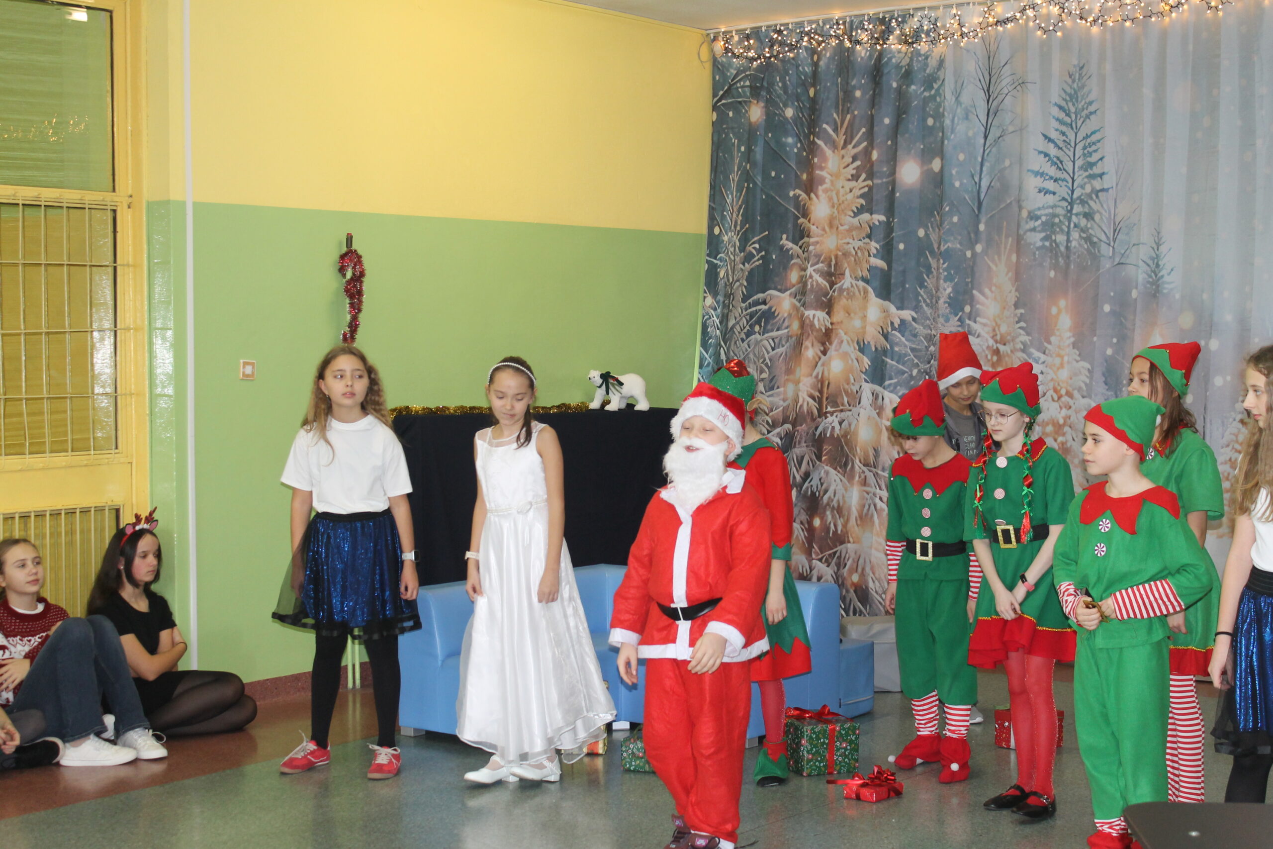 17 grudnia uczniowie klasy 4c zaprezentowali swoim koleżankom i kolegom z klas 1-8 przedstawienie pt. „Świąteczna zamiana miejsc”. Historia była pełna humoru, a jednocześnie niosła ważne przesłanie o empatii, życzliwości i wzajemnym zrozumieniu. Barwne stroje i zaangażowanie młodych aktorów zostały nagrodzone gromkimi brawami.