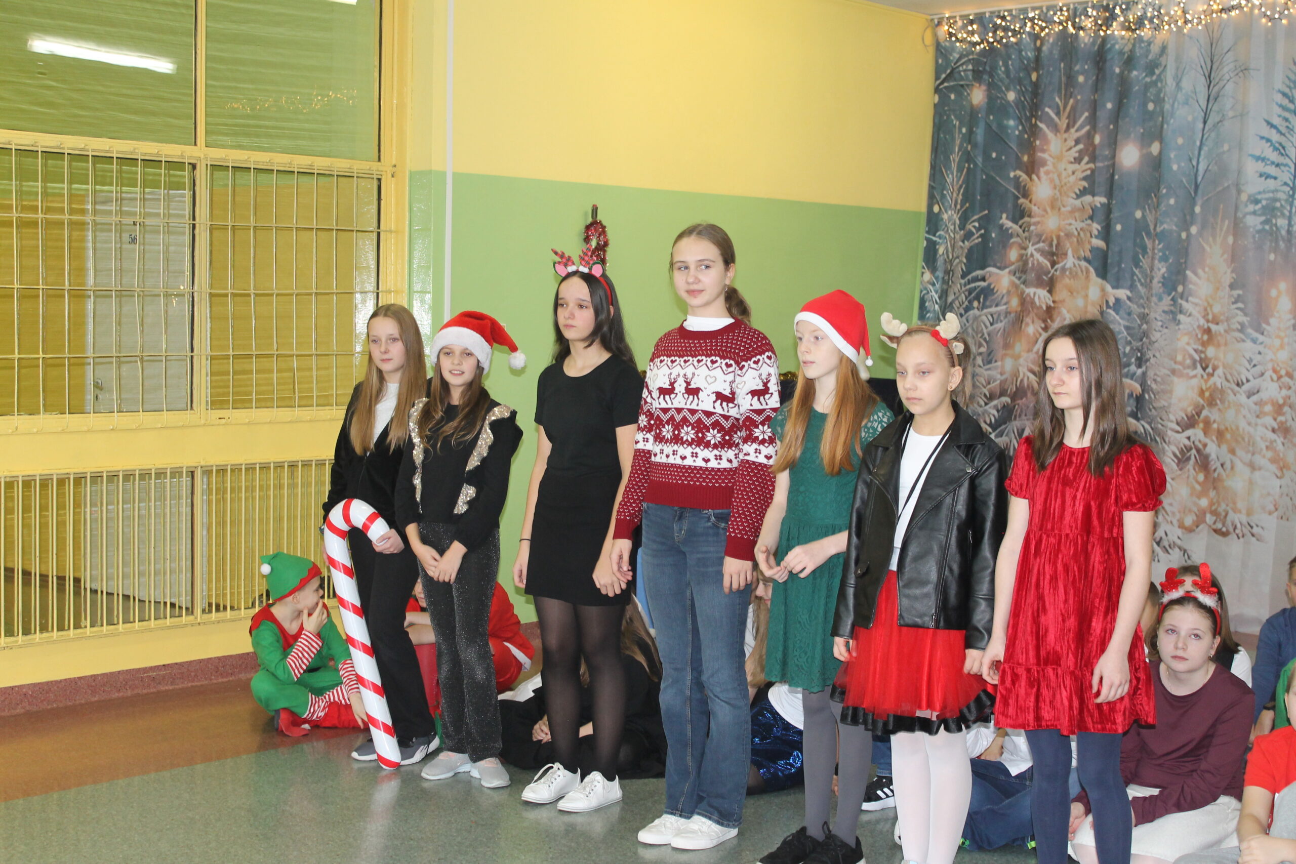 17 grudnia uczniowie klasy 4c zaprezentowali swoim koleżankom i kolegom z klas 1-8 przedstawienie pt. „Świąteczna zamiana miejsc”. Historia była pełna humoru, a jednocześnie niosła ważne przesłanie o empatii, życzliwości i wzajemnym zrozumieniu. Barwne stroje i zaangażowanie młodych aktorów zostały nagrodzone gromkimi brawami.