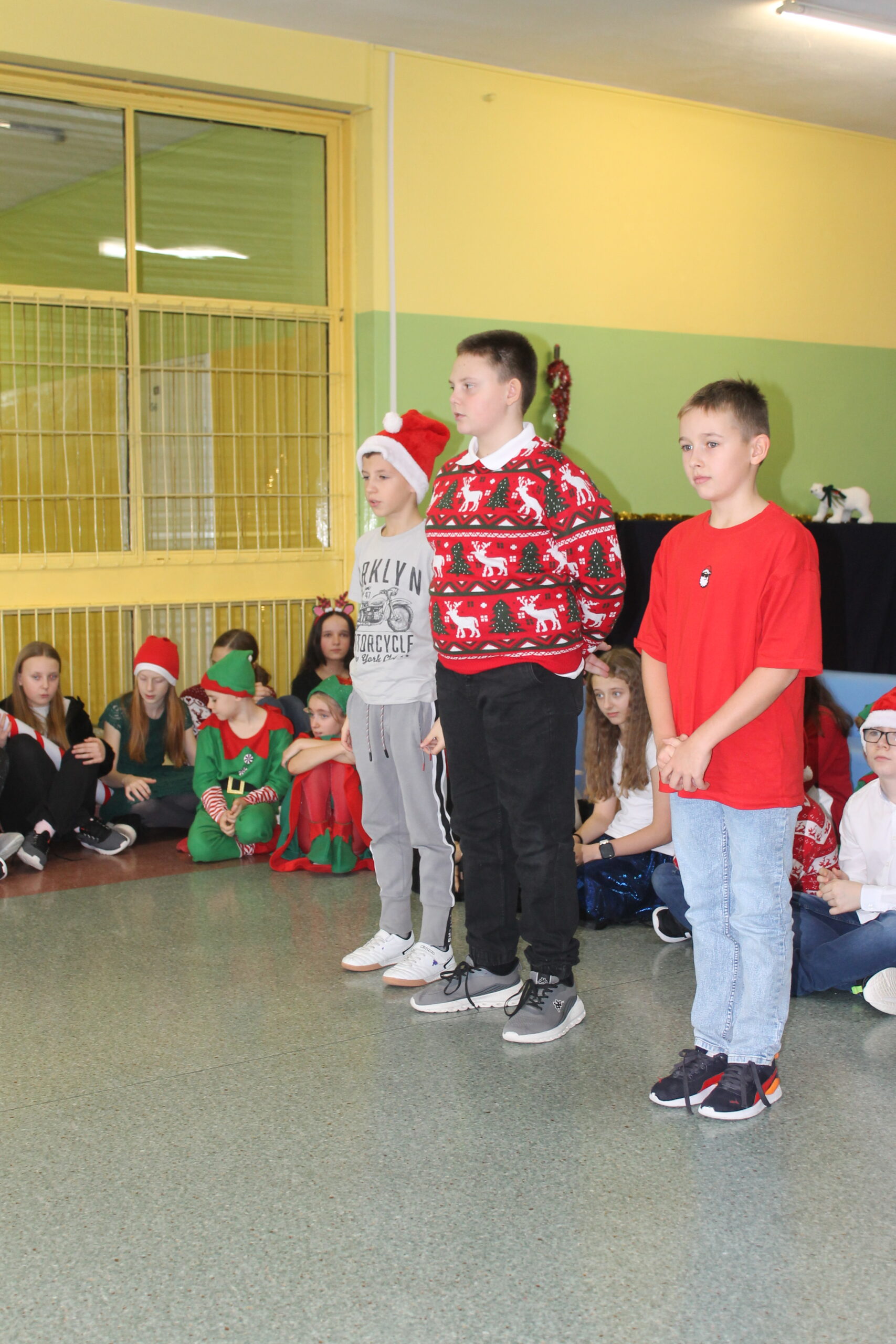 17 grudnia uczniowie klasy 4c zaprezentowali swoim koleżankom i kolegom z klas 1-8 przedstawienie pt. „Świąteczna zamiana miejsc”. Historia była pełna humoru, a jednocześnie niosła ważne przesłanie o empatii, życzliwości i wzajemnym zrozumieniu. Barwne stroje i zaangażowanie młodych aktorów zostały nagrodzone gromkimi brawami.